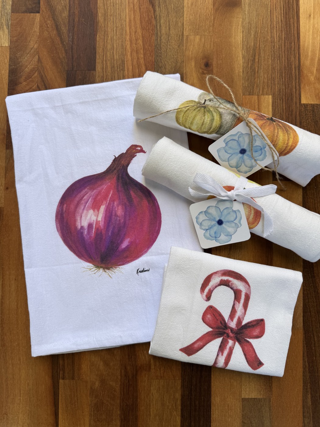 Quince & Roses watercolor towels arranged on a wooden table